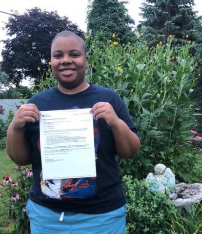 Photo of Lauren Reynolds holding a scholarship letter